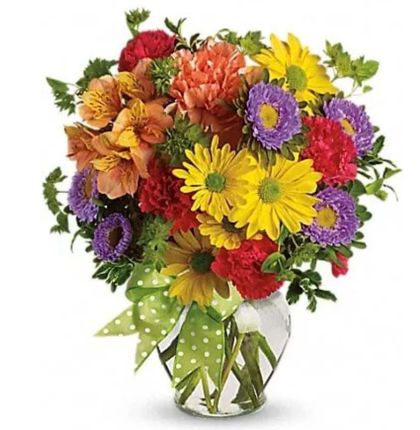 Colorful mixed bouquet in a clear glass vase with a green polka-dot ribbon