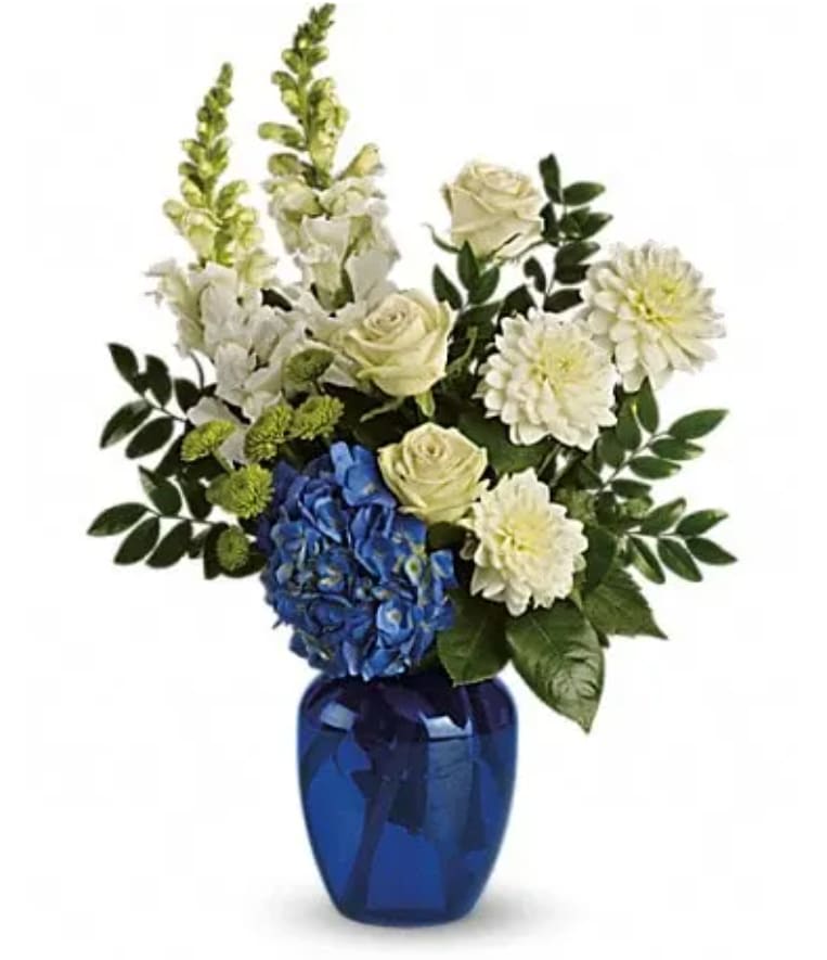 Blue vase with white and blue flowers and greenery