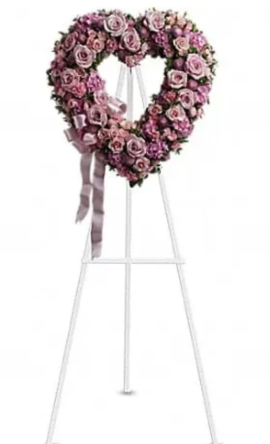 Heart-shaped pink rose wreath on a standing easel with ribbon
