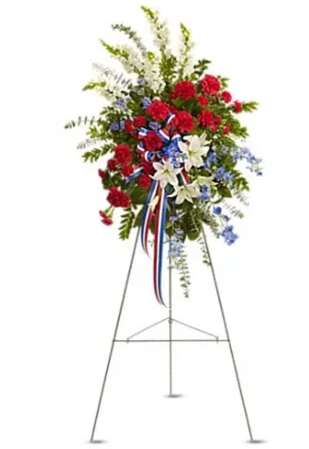 Standing floral spray with red, white, and blue flowers on an easel
