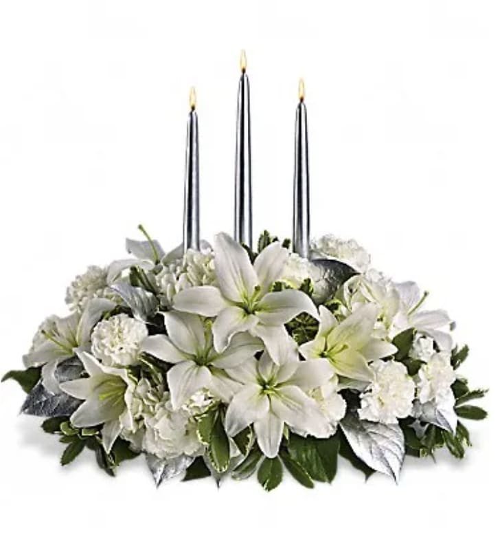 White floral centerpiece with three tall candles