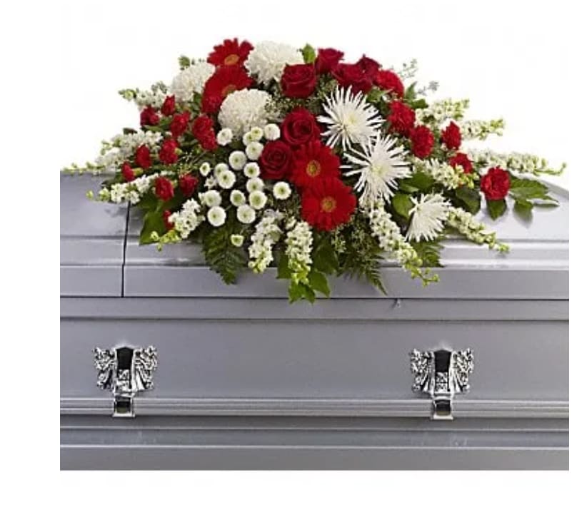 Red and white funeral spray on a gray casket