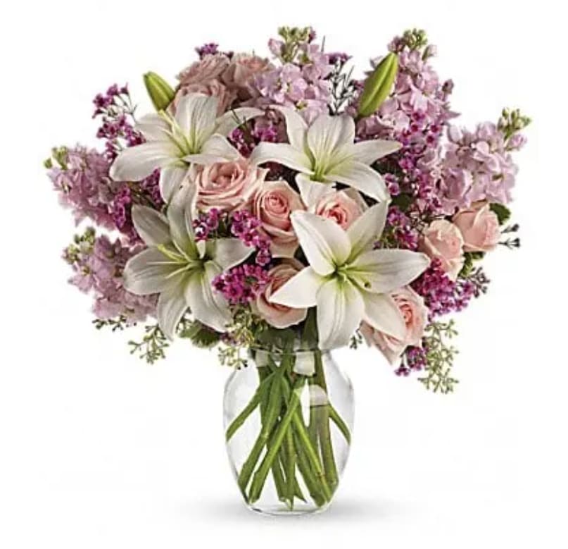 Bouquet of pink roses and white lilies in a clear glass vase