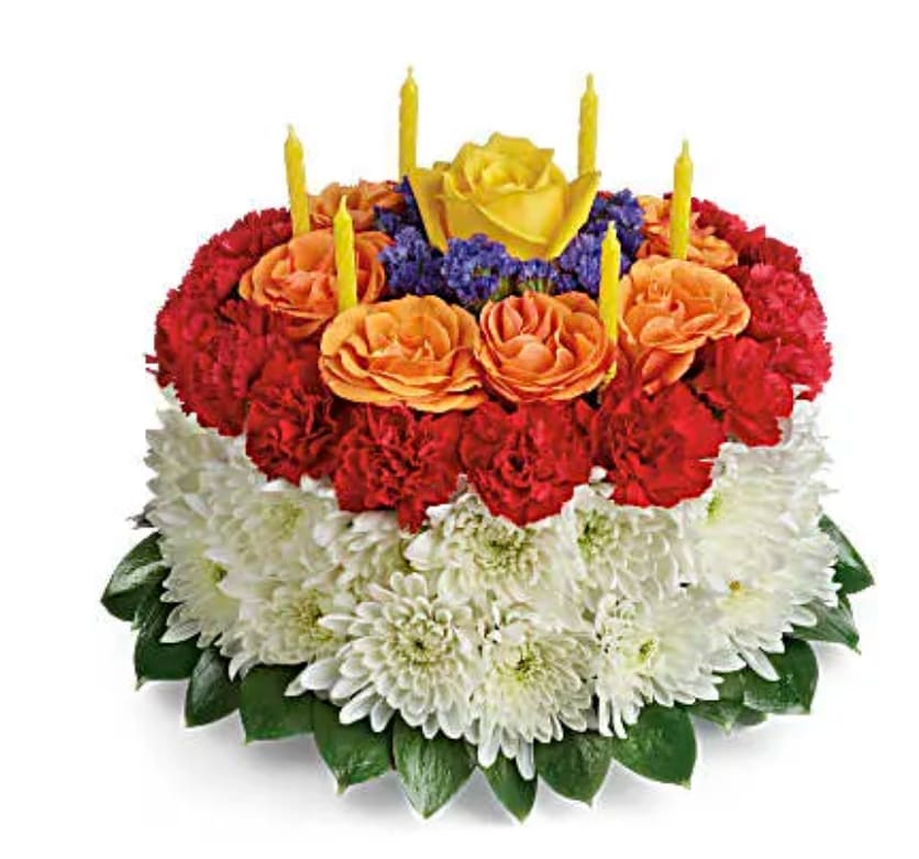 Round floral cake with candles in red, orange, yellow, and white flowers