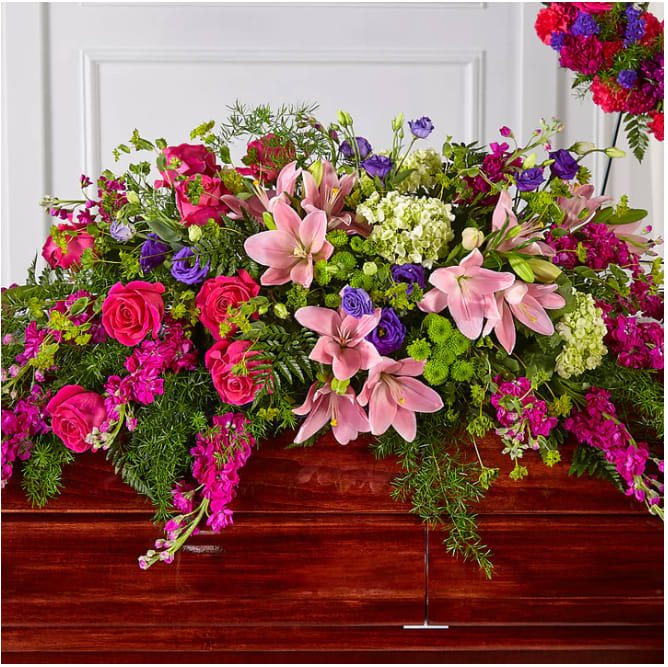 Large casket spray with pink lilies, roses, and purple flowers
