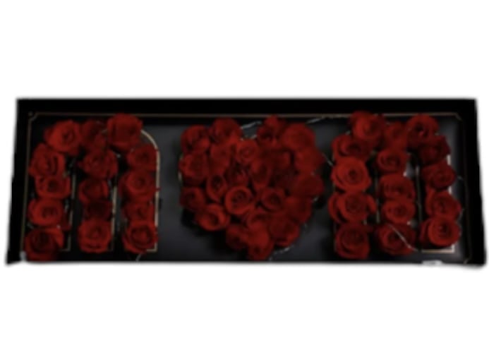 Red roses arranged to spell "MOM" in a black frame