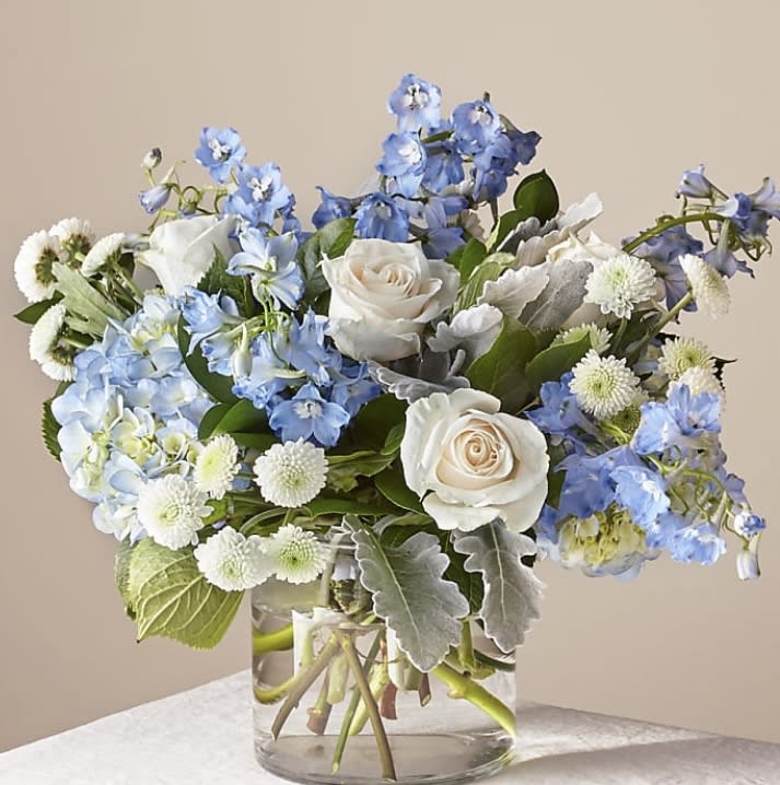 Blue and white flower arrangement in a clear glass vase