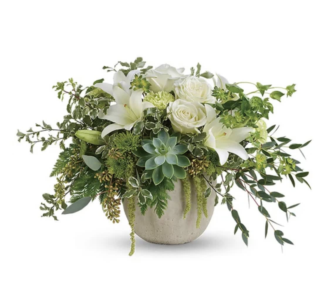 White lilies and roses in a ceramic vase with trailing greenery