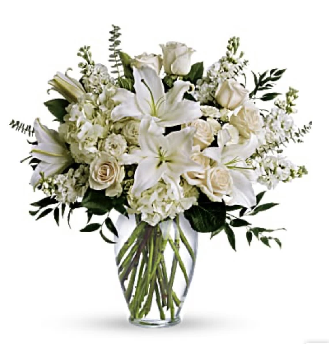 White lilies and roses arranged in a clear glass vase