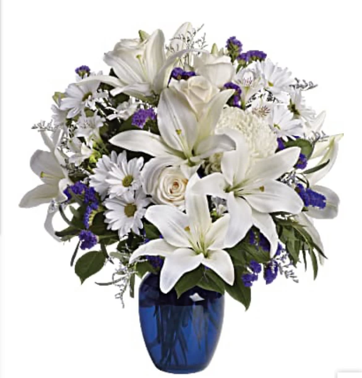 White lilies and daisies arranged in a blue vase with purple accents