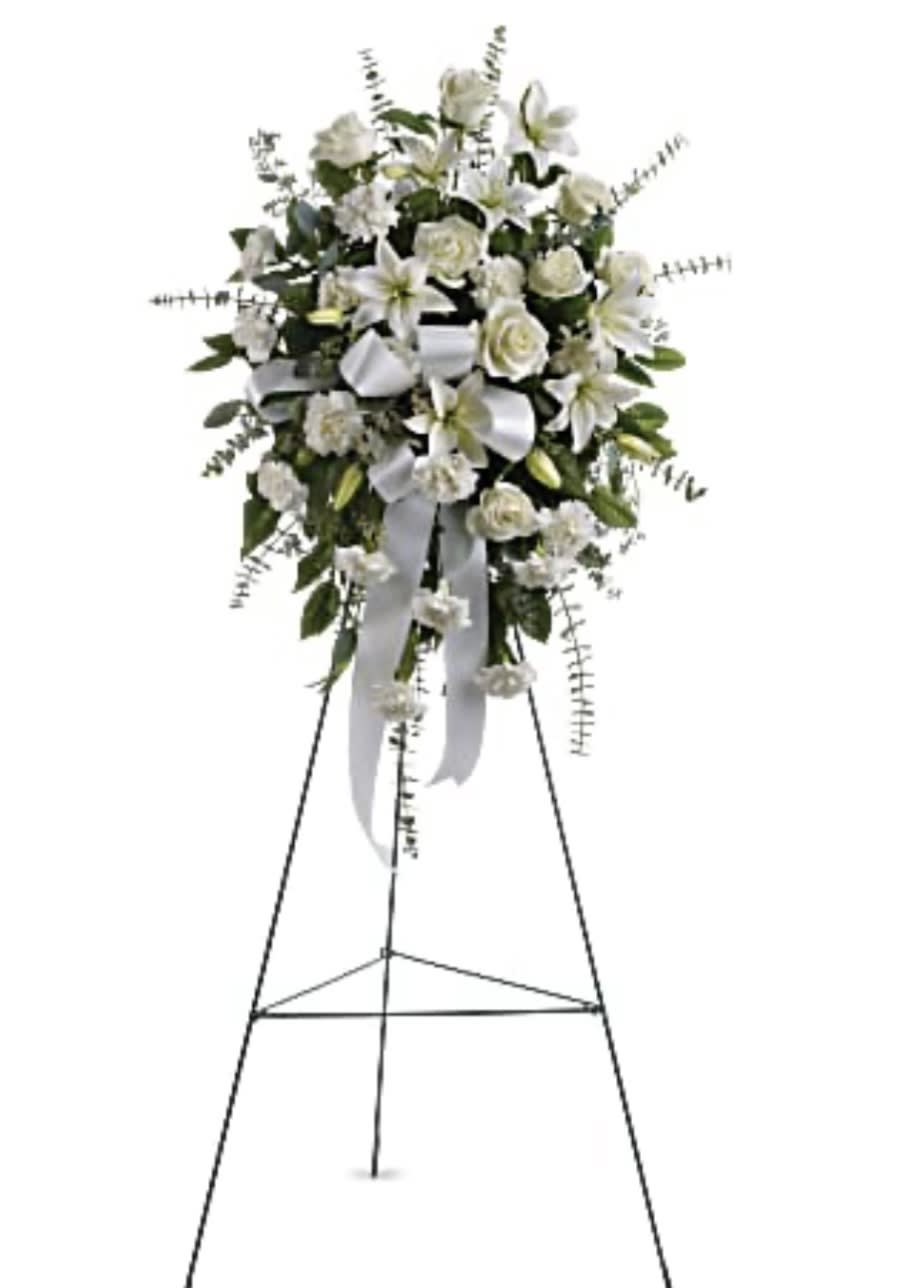White floral standing spray on an easel with a ribbon