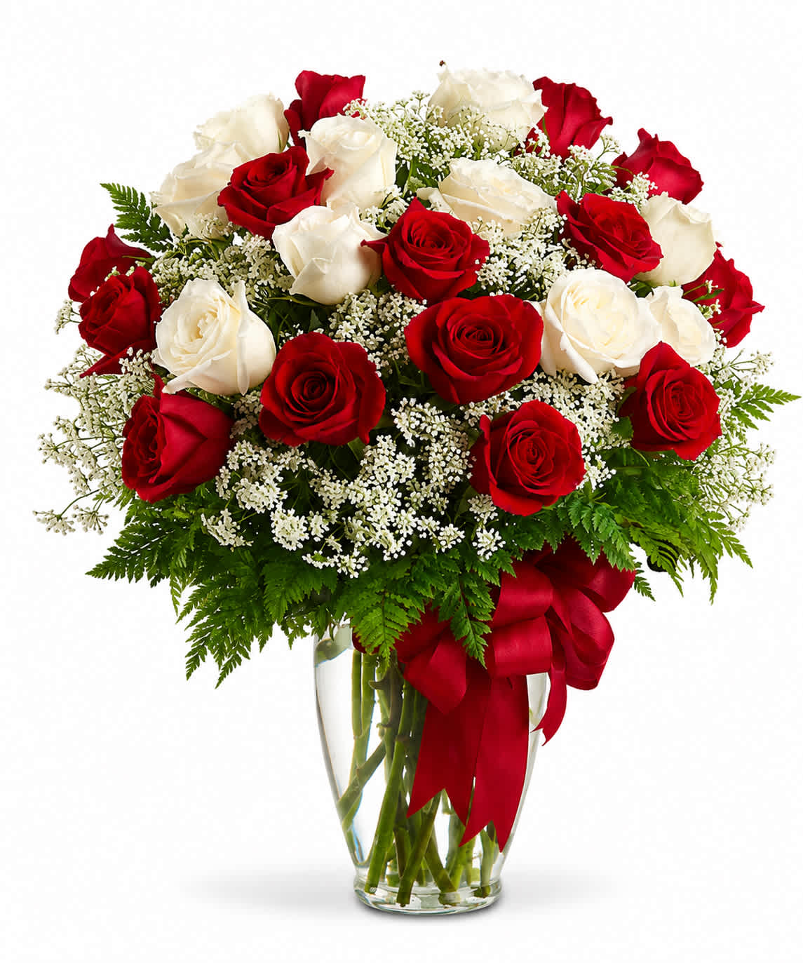 Red and white roses in a clear glass vase with a red ribbon