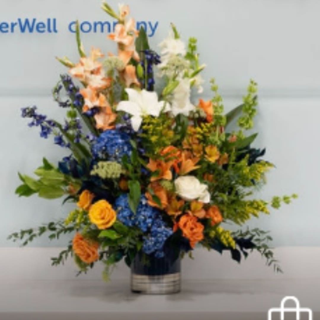 Tall mixed bouquet in a vase with white, orange, and blue flowers