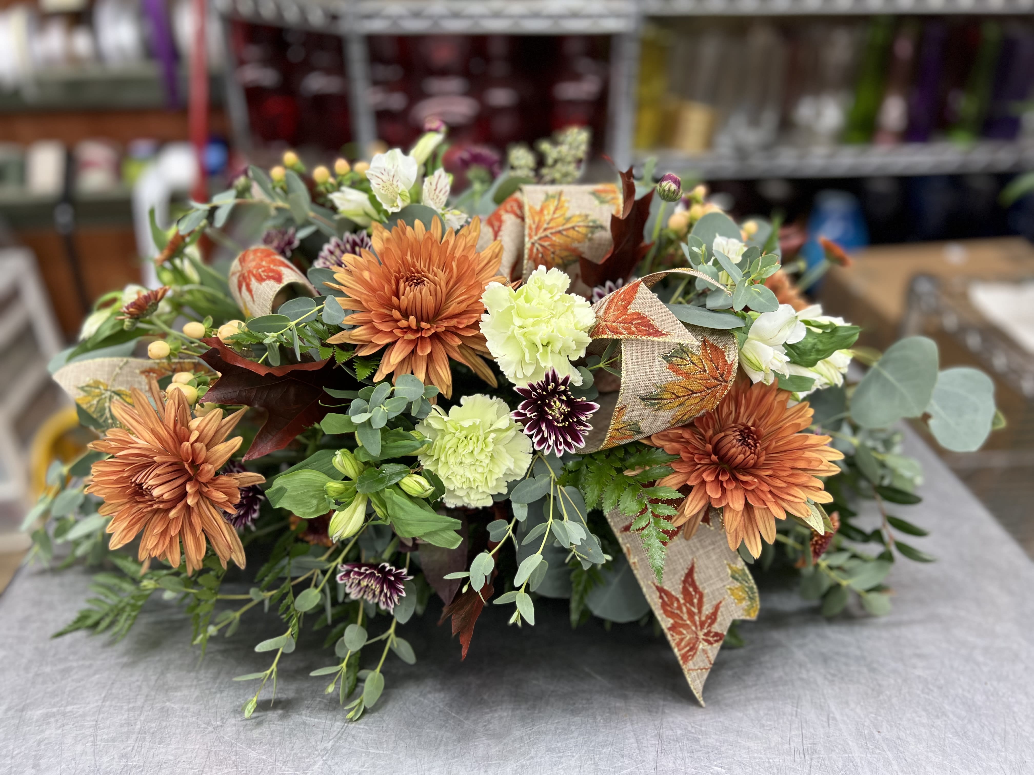 Autumn floral arrangement with orange chrysanthemums and pale green carnations
