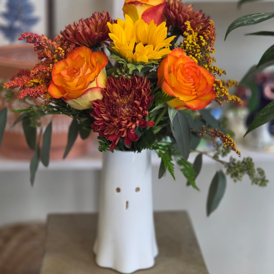 Orange roses and burgundy mums in a white vase
