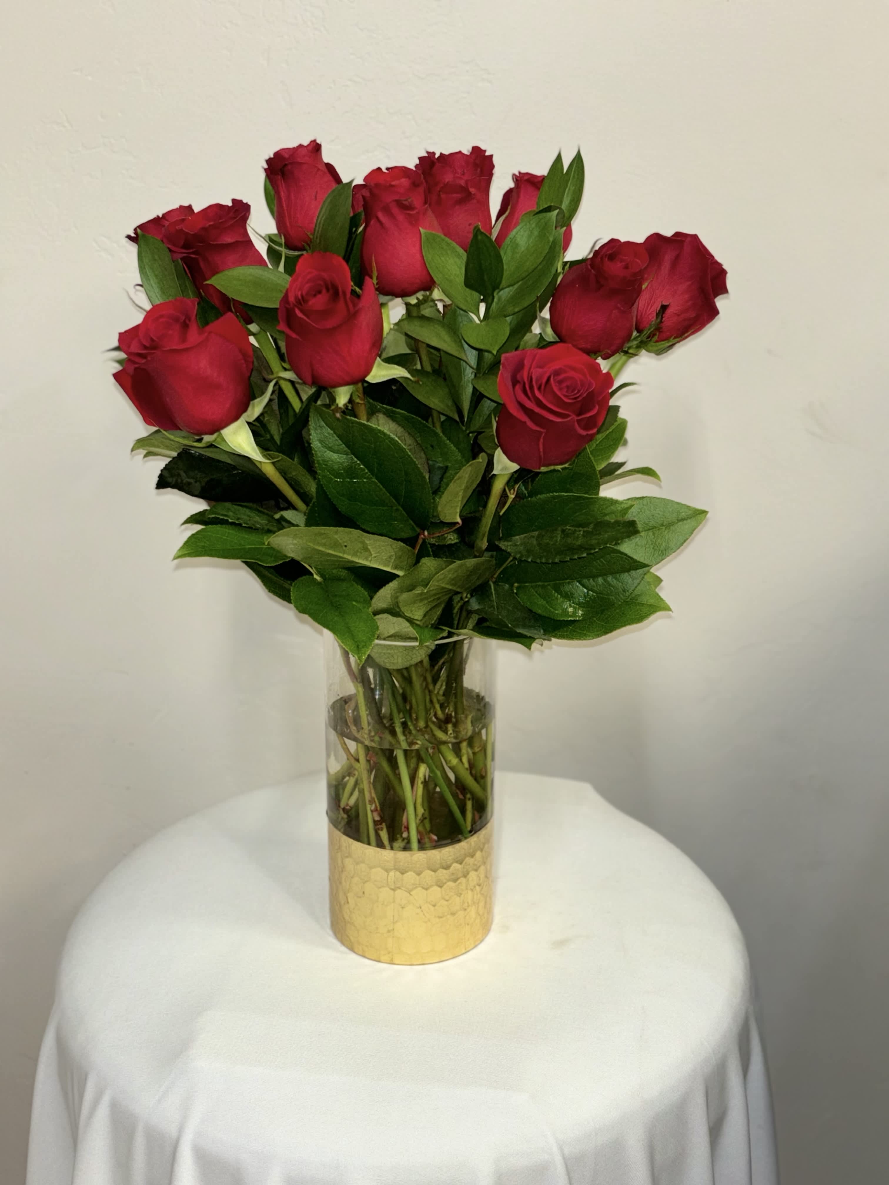 Golden Elegance Bouquet  - This arrangement features a dozen exquisite roses showcased in a clear vase with a touch of opulence – a golden bottom that adds a radiant charm, elevating the overall elegance of the bouquet.  Standard 12 roses Deluxe is 18 roses 