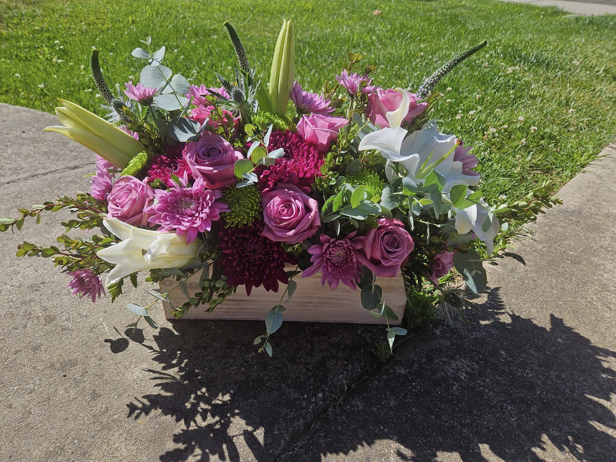 Pink and white floral arrangement in a rectangular wooden box