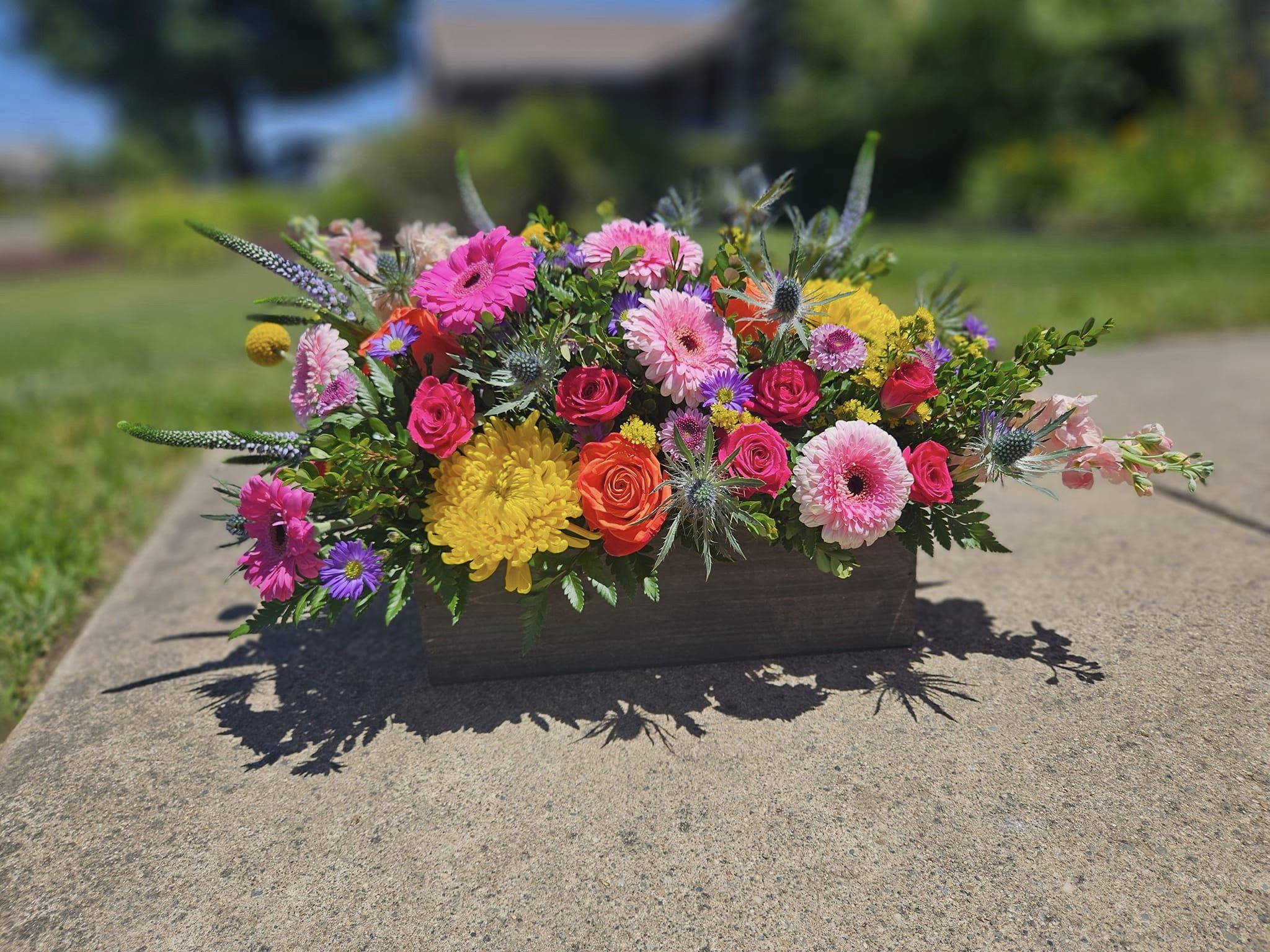 Colorful mixed flower arrangement in a rectangular wooden container