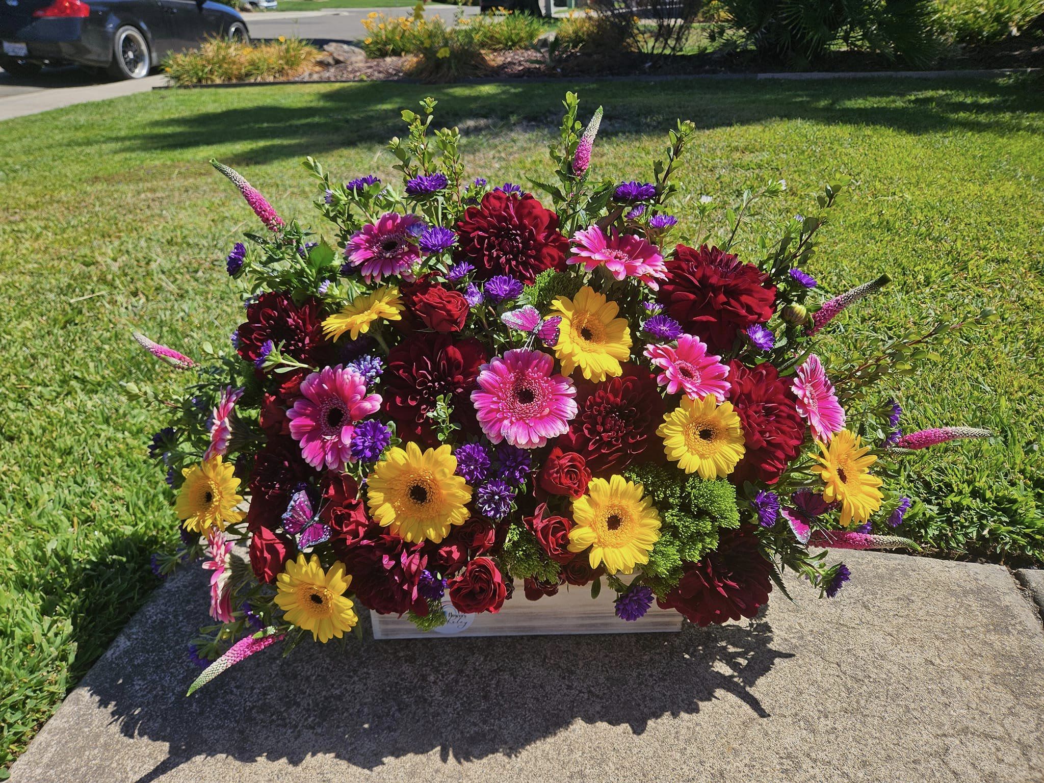Bright mixed flower arrangement in a low rectangular container