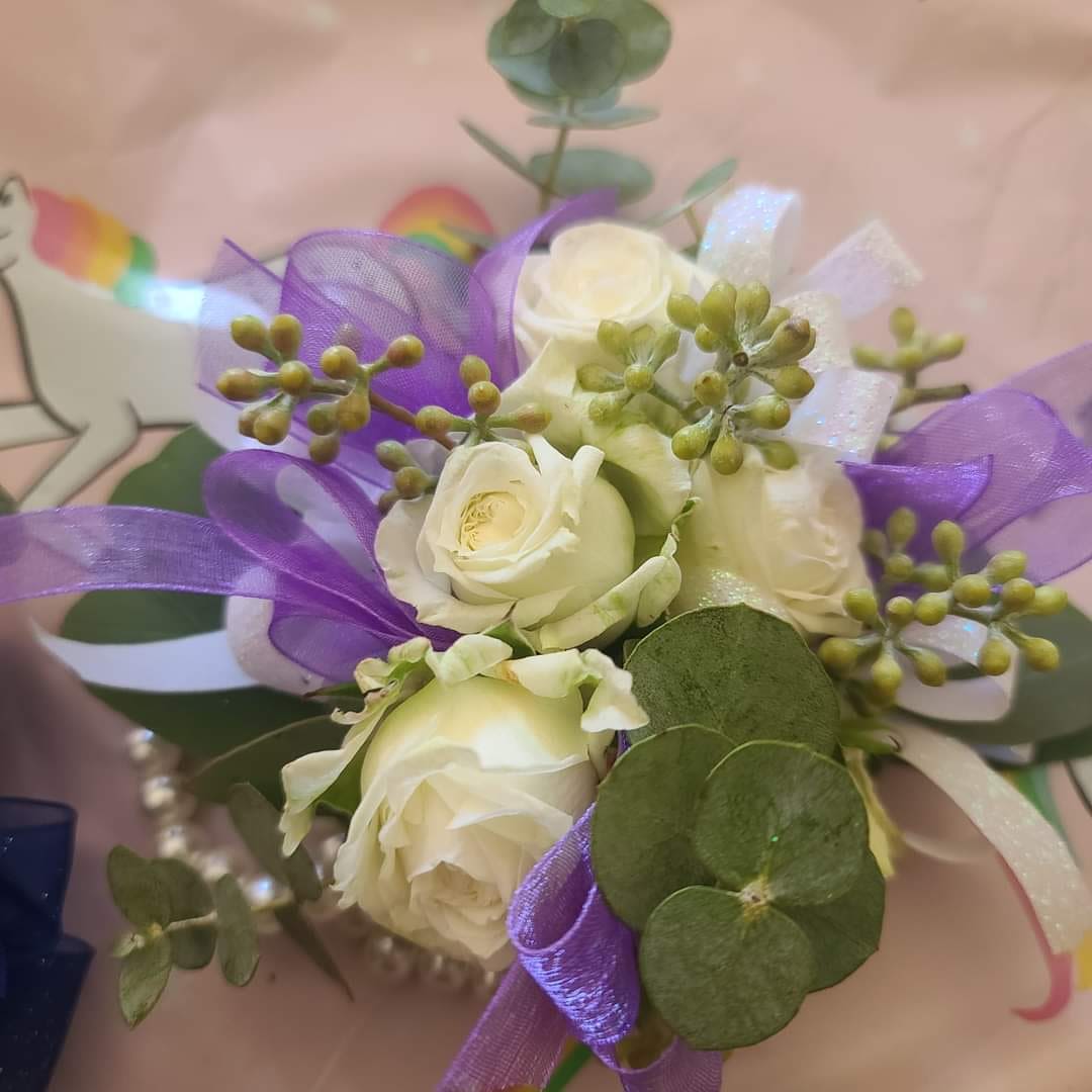 White rose bouquet with purple ribbon and green berries