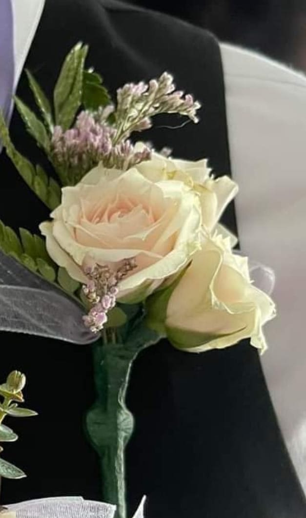 Boutonniere with cream roses and small pink filler flowers