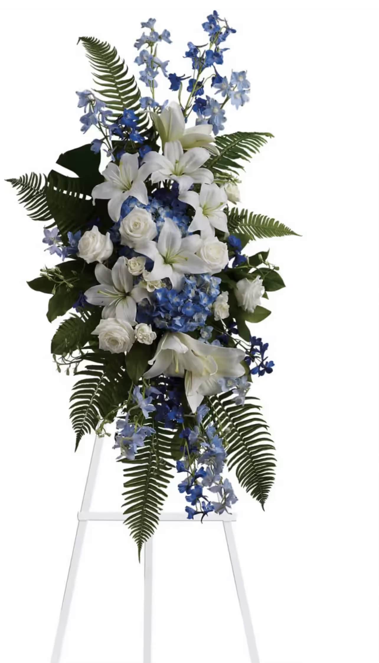 White lilies and blue flowers on a standing easel spray