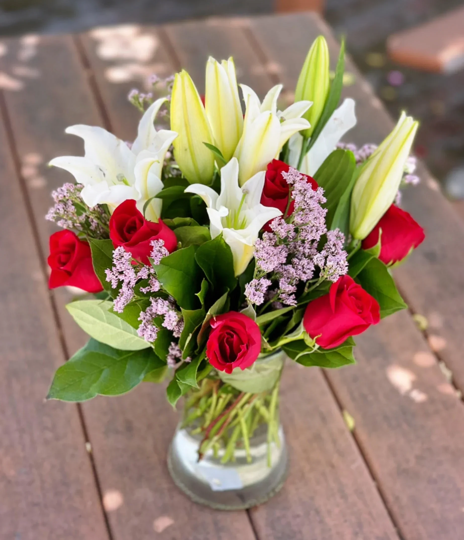 My Girl - 6 Red Roses surrounded by white oriental lilies and limonium beautifully arranged in a glass gathering vase. 