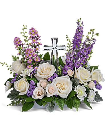 Teleflora's poised with Love - Soft and serene, this artistic array of cream and lavender blooms around a radiant crystal cross keepsake is a heartfelt expression of love.