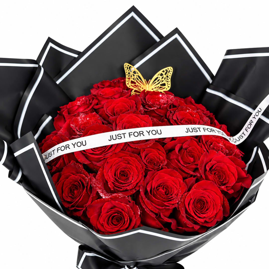 Bouquet of red roses wrapped in black paper with a butterfly topper