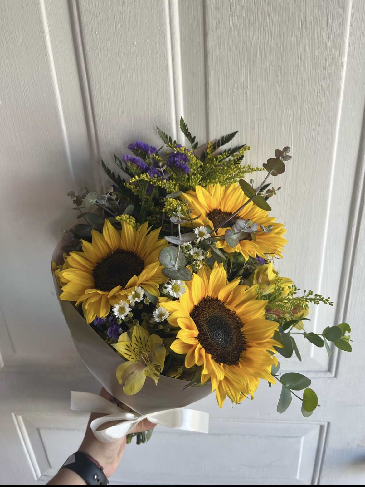 3 Sunflowers in a Wrapped Bouquet - 3 Sunflowers in a Wrapped Bouquet with Yellow Alstroemeria, Eucalyptus, Purple Statice, and Solidago. Paper color may vary depending on availability