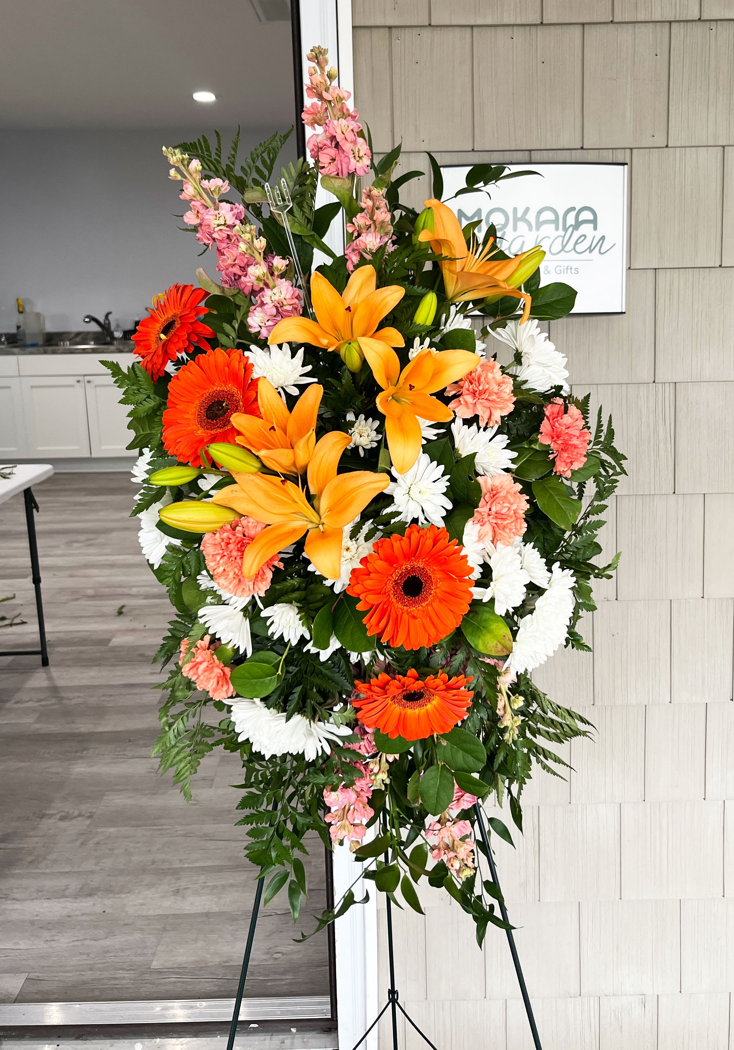 Treasured Lilies Spray - Celebrate the light they brought into your life with this bright, beautiful spray of lilies and gerberas in sunshiny shades of peach and orange. A truly uplifting addition to the memorial service.