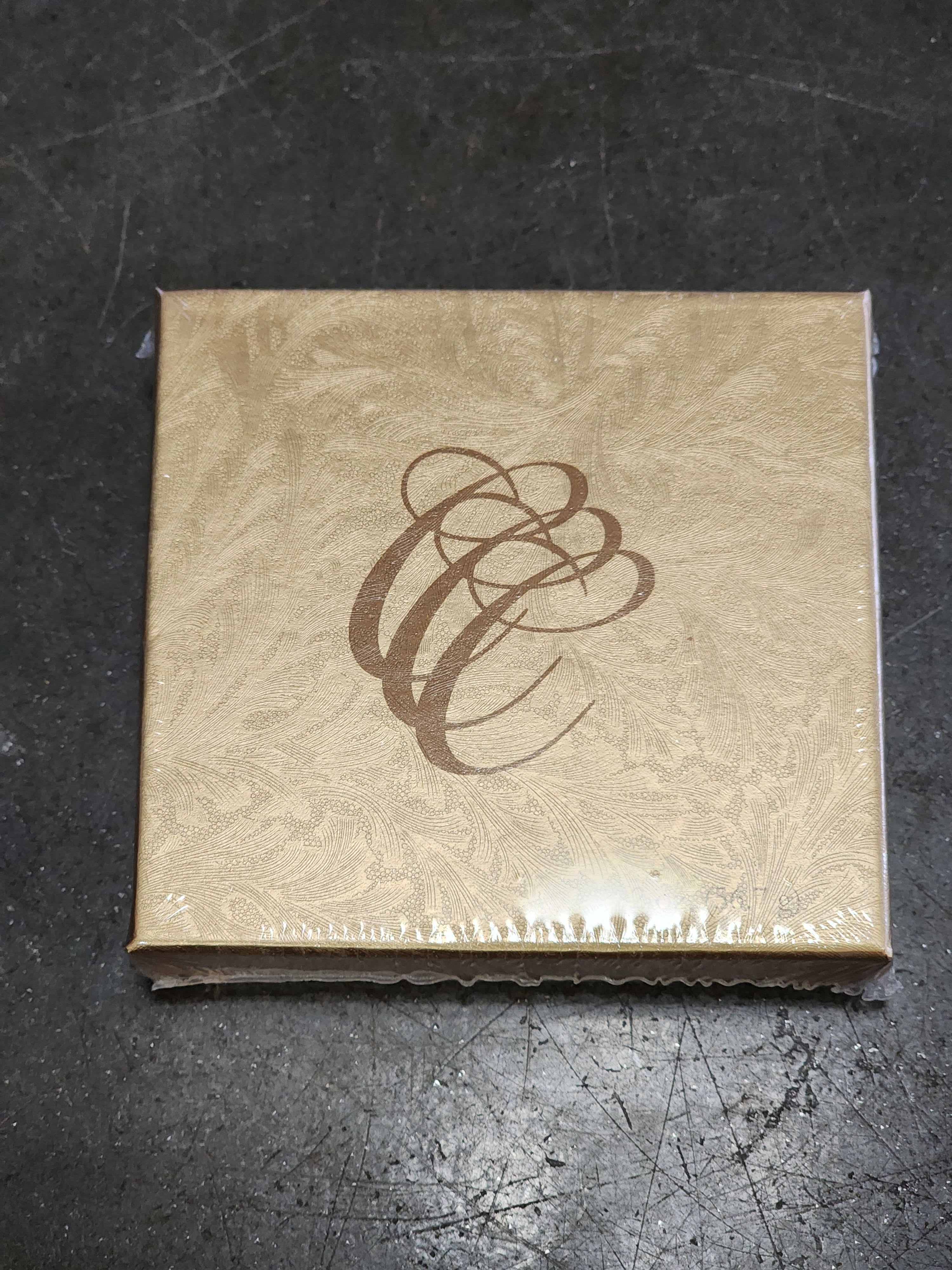 Gold decorative gift box with a brown abstract swirl design