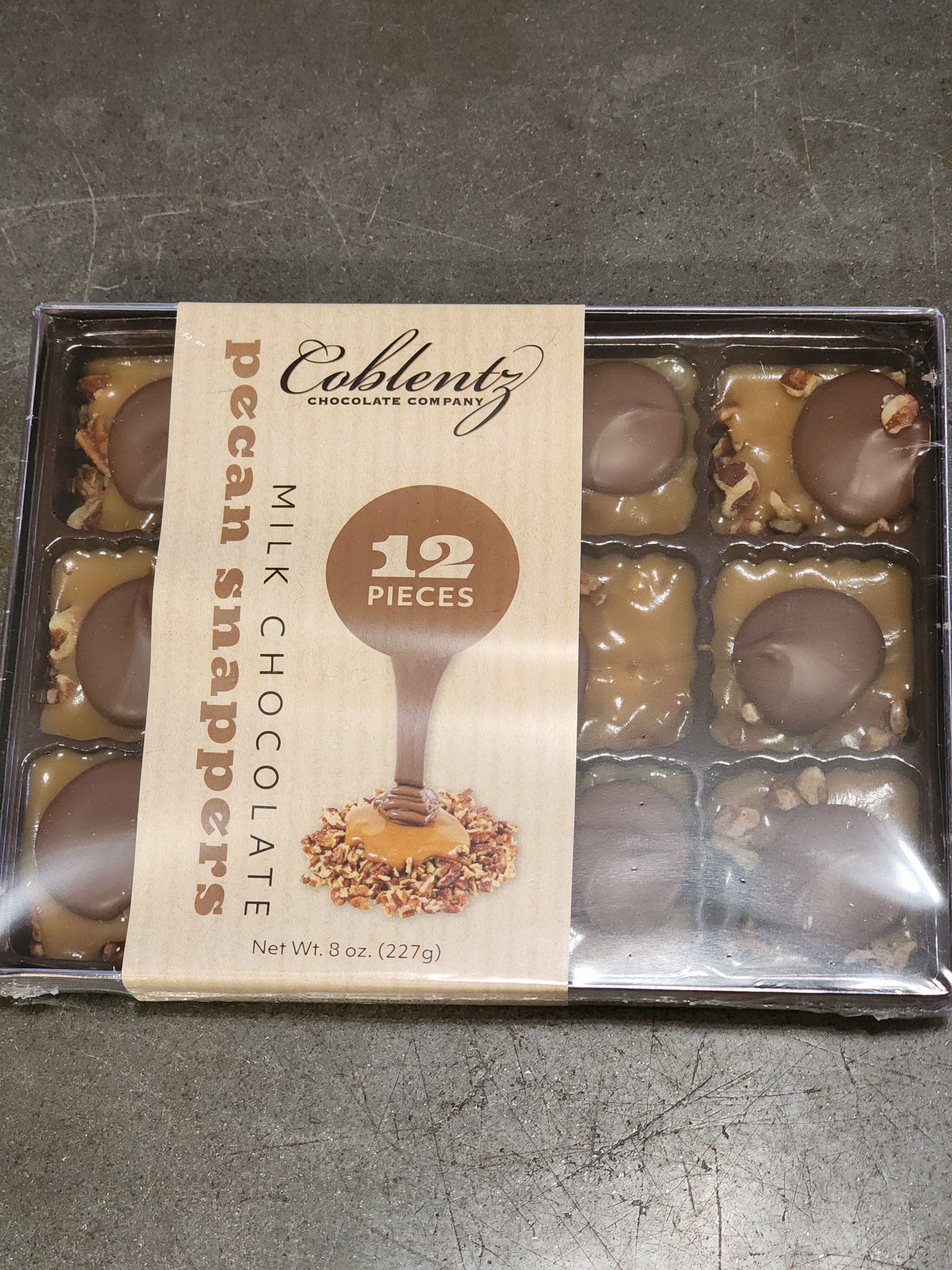 Box of pecan snapper milk chocolates in plastic tray