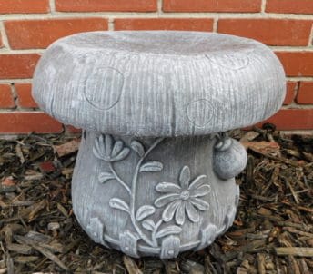 Gray mushroom-shaped garden stool with floral relief details