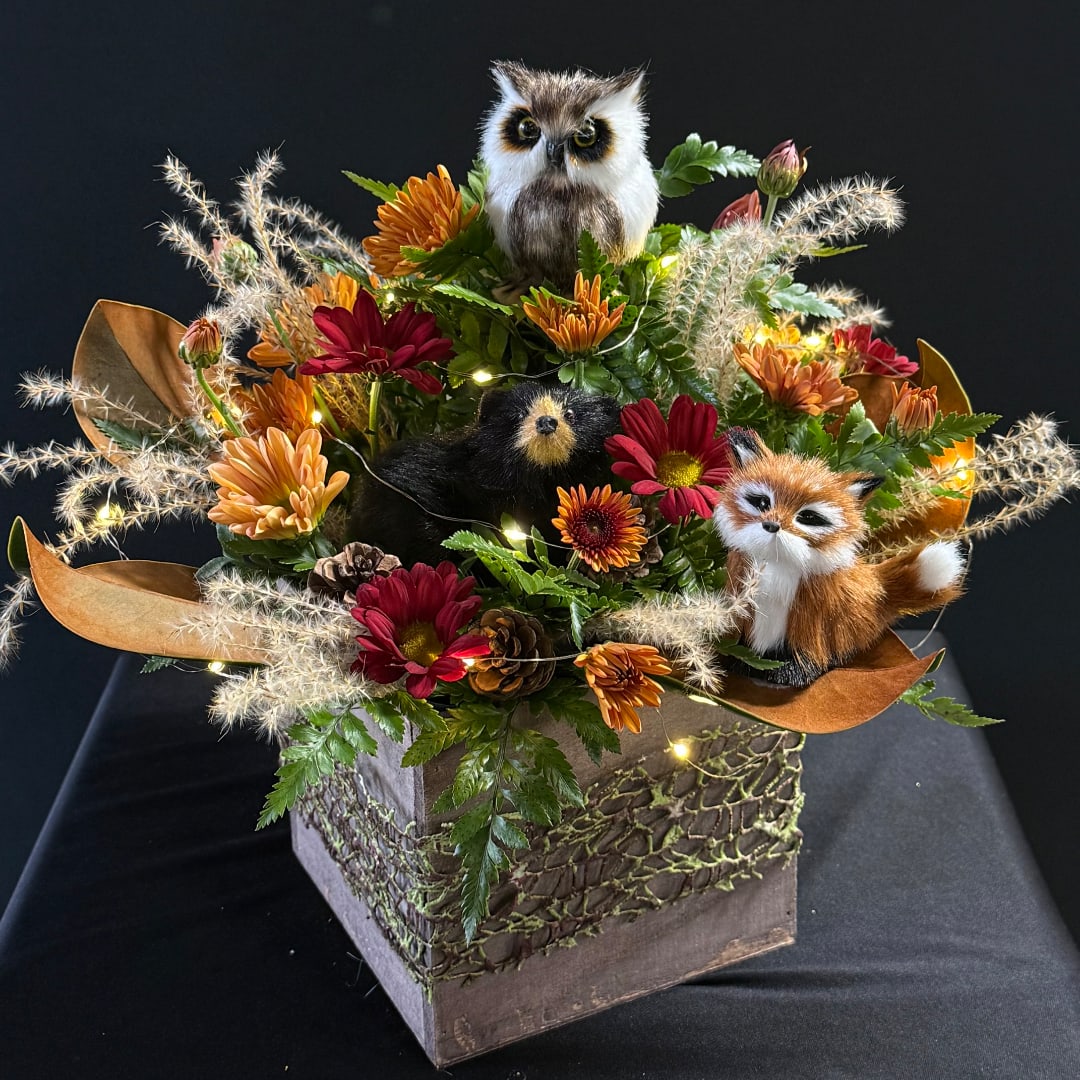 Autumn floral arrangement with plush owl and fox figures in a square box
