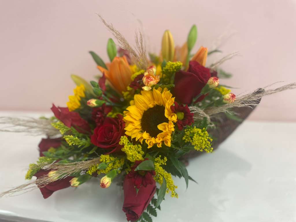 Bouquet of red roses and a yellow sunflower with orange lilies