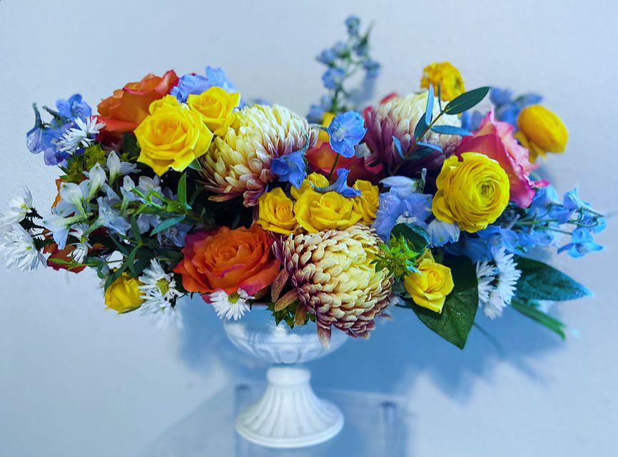 Colorful mixed bouquet in a white pedestal vase