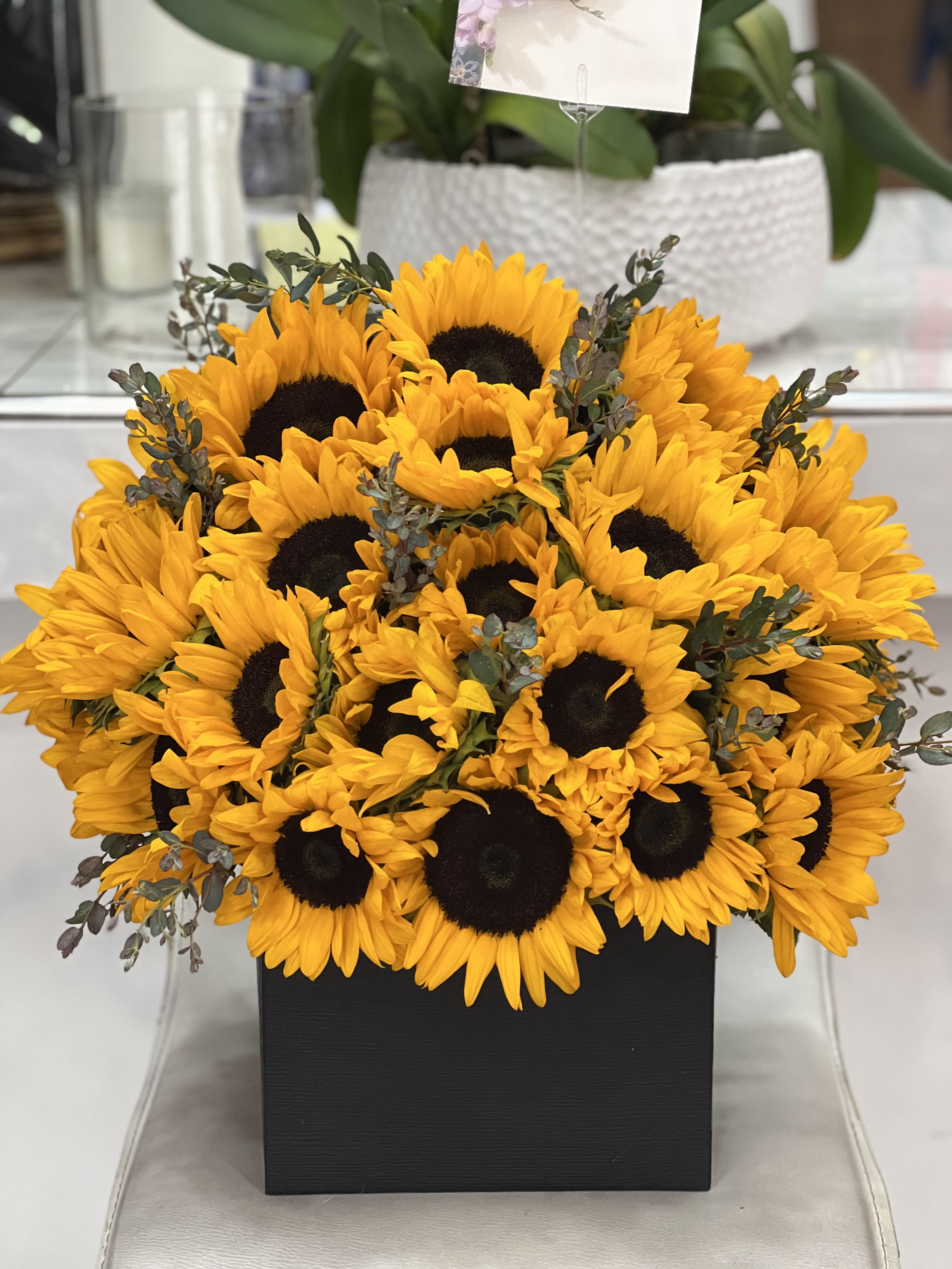 Bouquet of bright yellow sunflowers in a black box