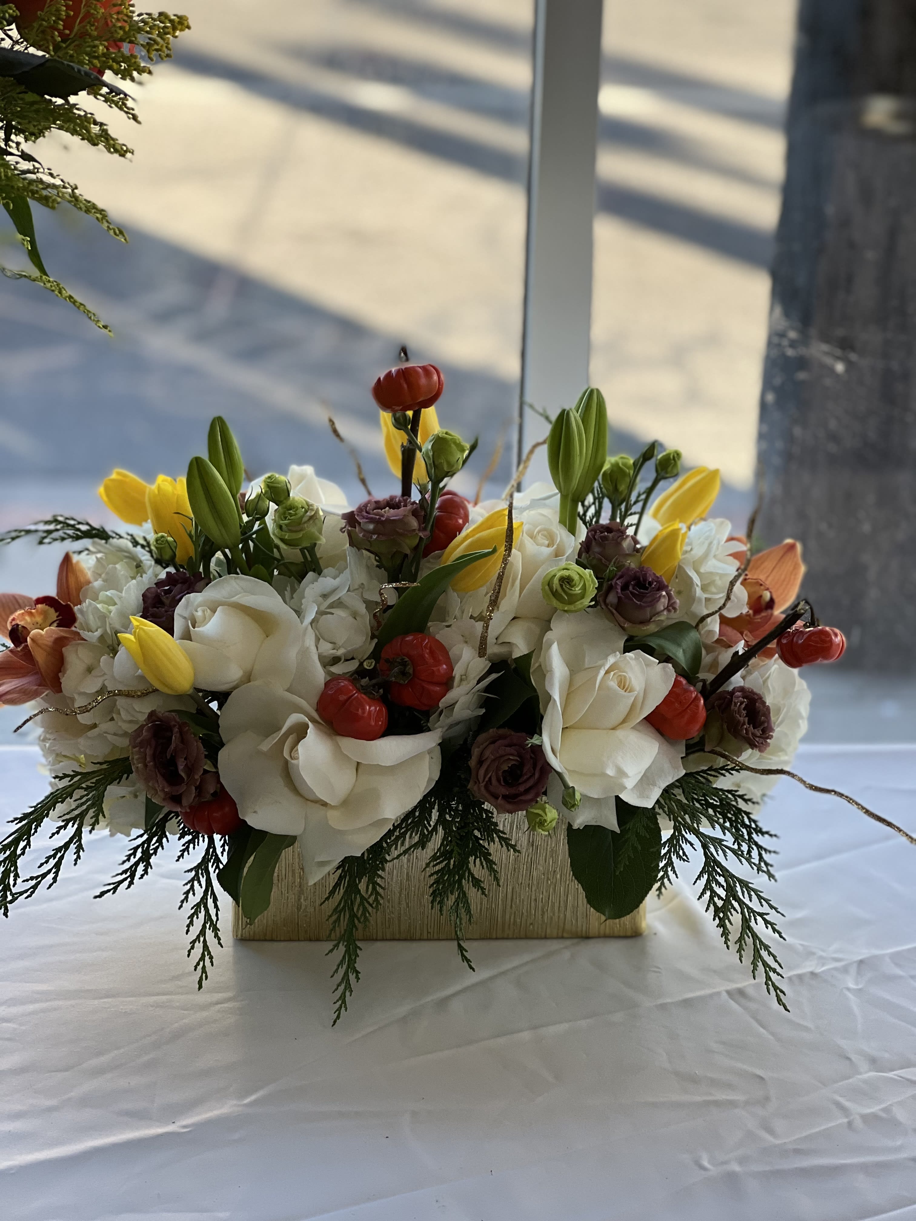 White and yellow floral arrangement in a rectangular vase