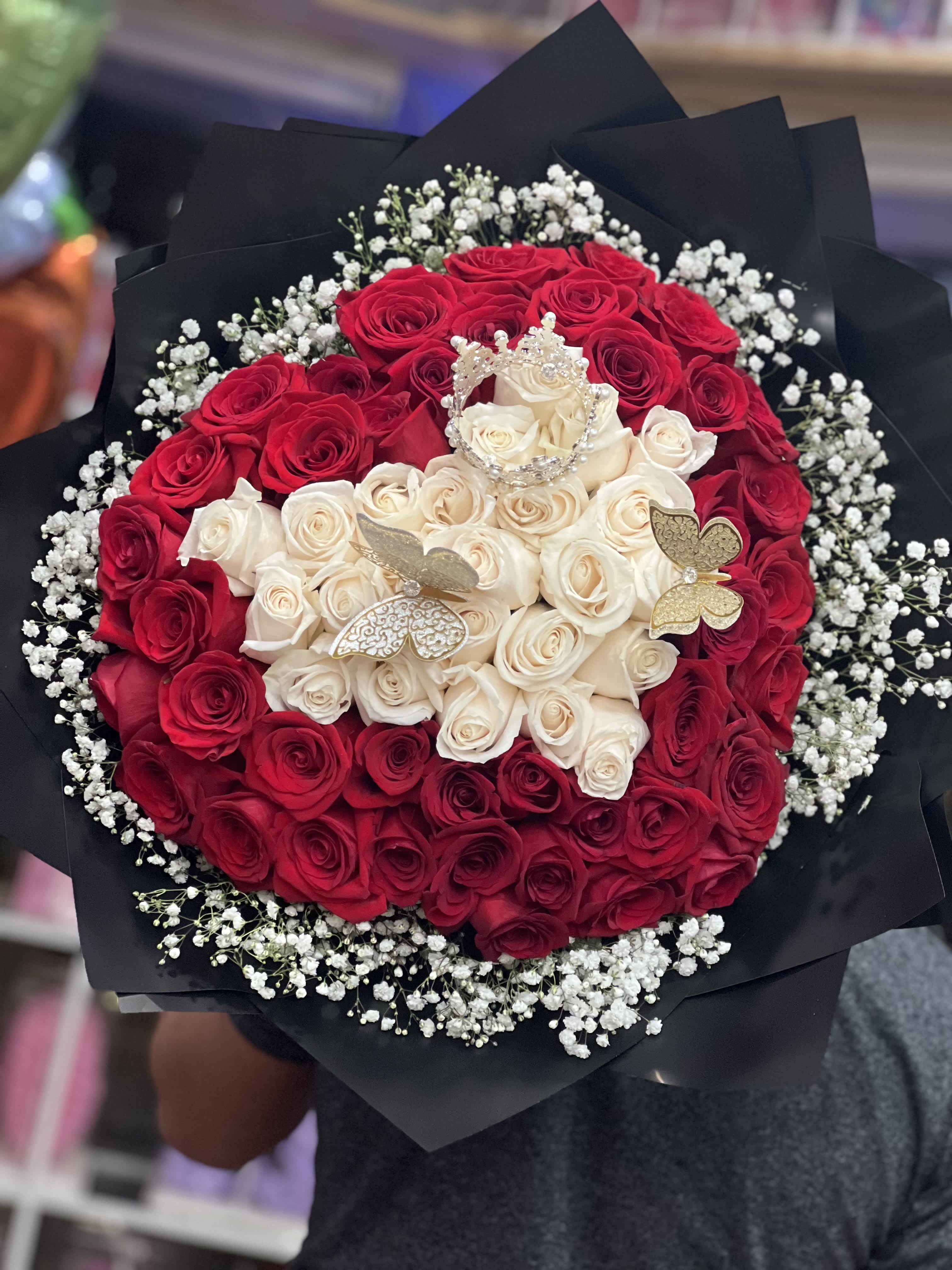 Bouquet of red and white roses with baby’s breath in black wrap