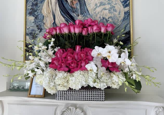 Pink roses and white orchids arranged in a decorative box