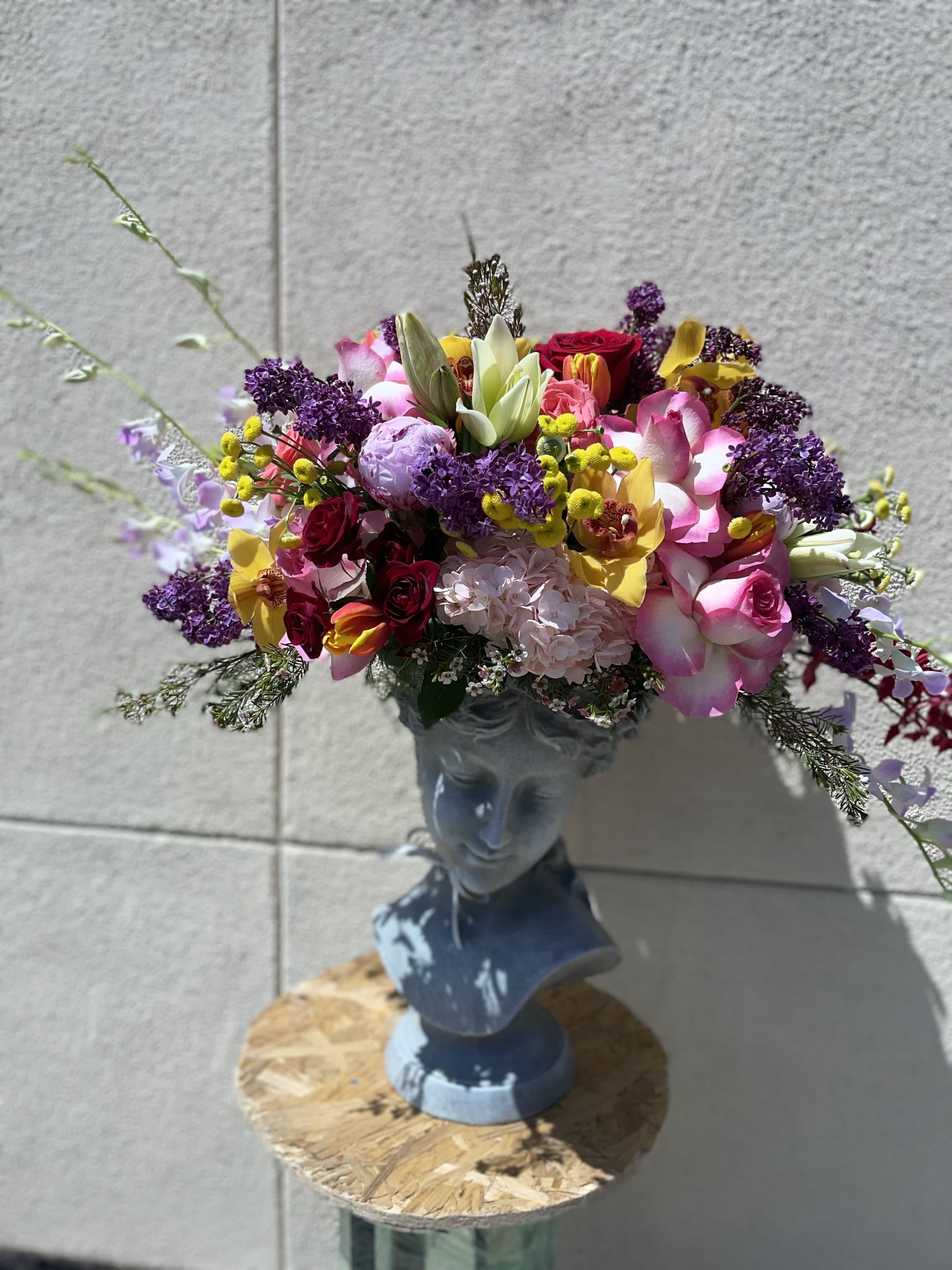 Colorful mixed bouquet arranged in a blue bust vase