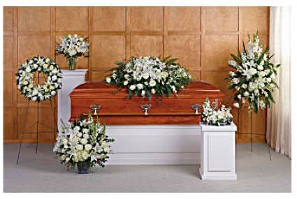 White funeral flowers arranged around a casket