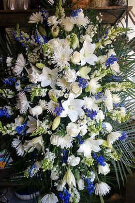 Blue and White Sympathy Standing Spray - In some instances, our photo may represent an overall theme or look and include a one-of-a-kind which cannot be exactly replicated.  Although the actual bouquet may not precisely match the photo, its temperament will. Occasionally, substitutions of flowers and/or containers happen due to weather, seasonality and market conditions which may affect availability. If this is the case with the gift you’ve selected, we will ensure that the style, theme and color scheme of your arrangement is preserved and will only substitute items of equal value or higher value.  If any design elements are of major importance to your order, please include them in the florist instructions at checkout or contact us to ensure availability. 