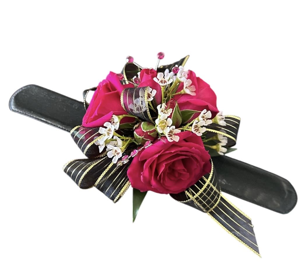 Pink rose corsage with white filler flowers on a black wristlet