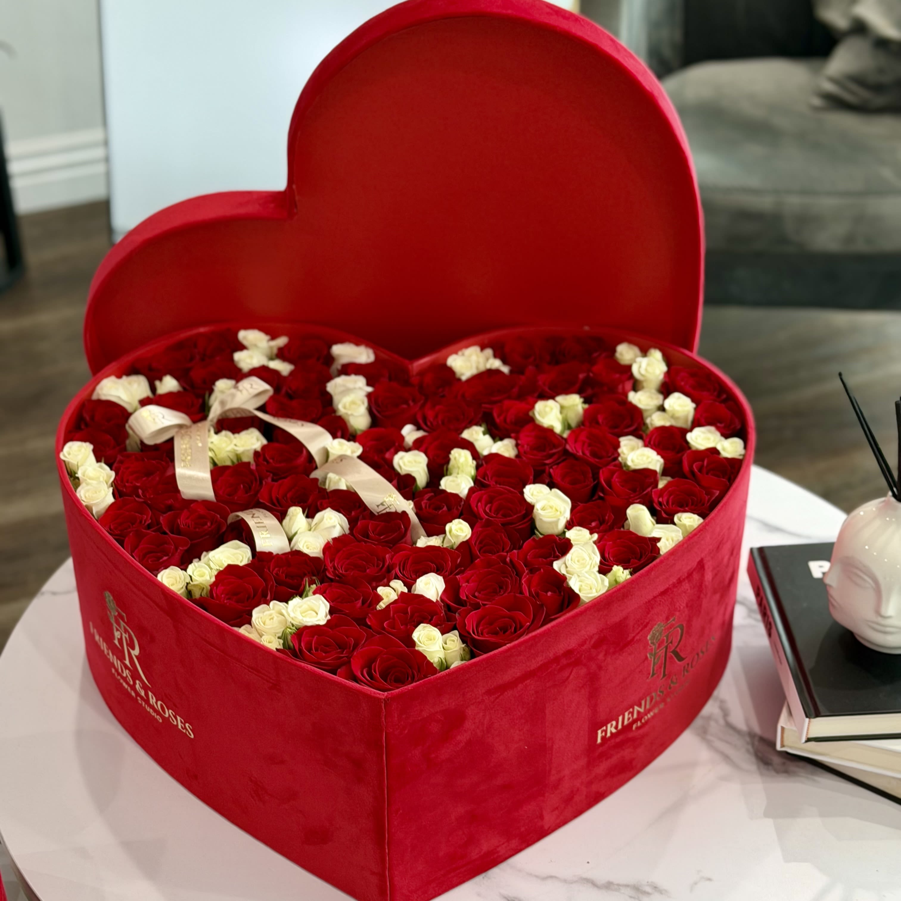 Heart-shaped red box filled with red and white roses