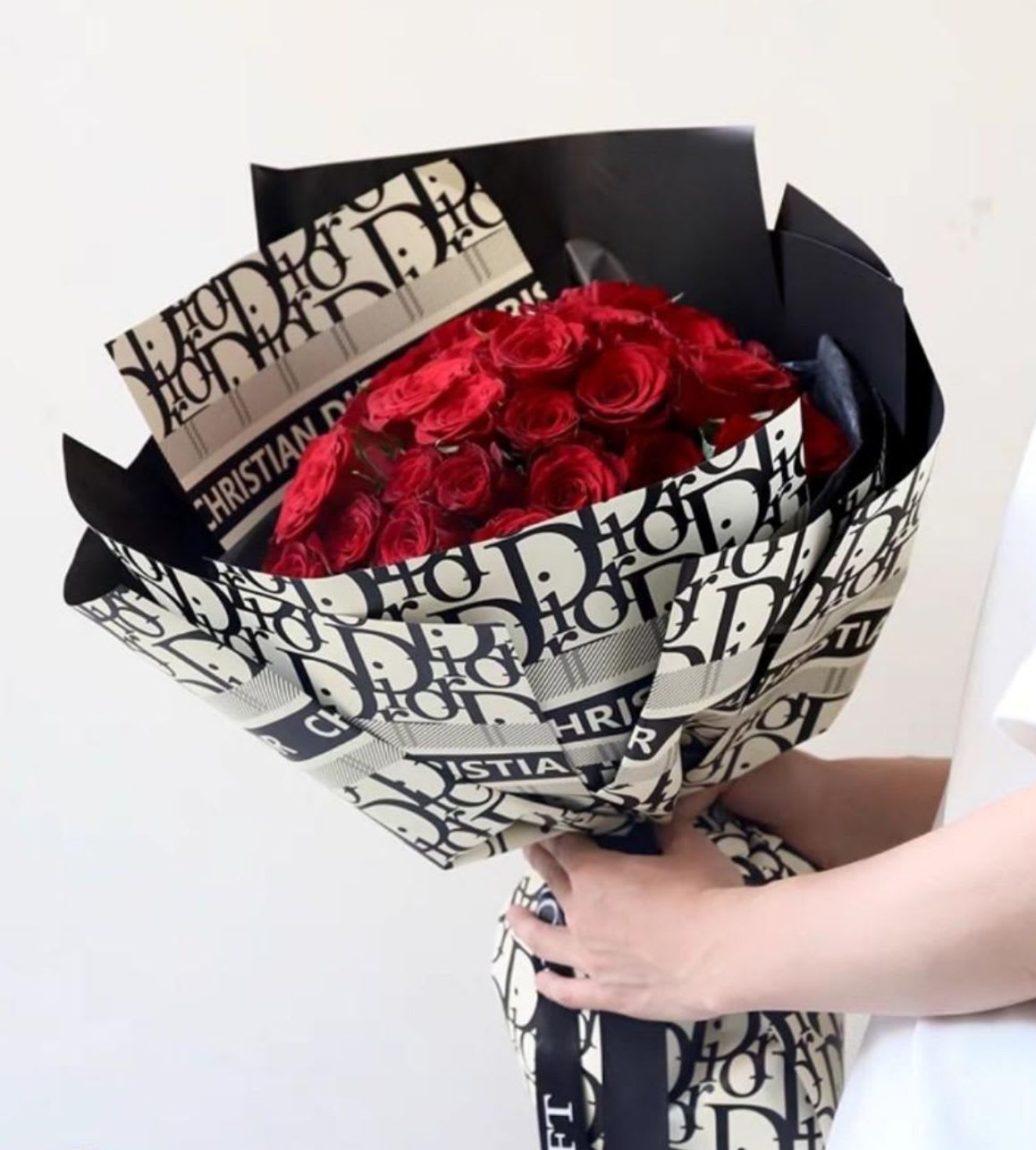 Bouquet of red roses wrapped in black-and-white Dior paper