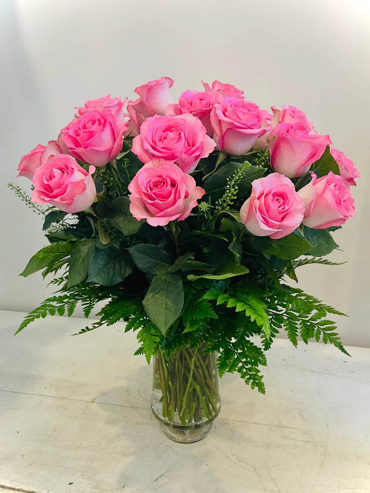 Pink roses arranged in a clear glass vase