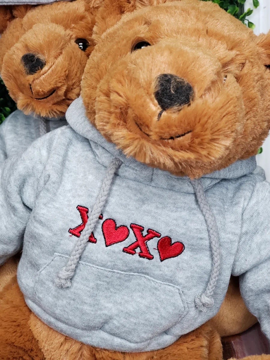 Two teddy bears in gray hoodies with red heart embroidery