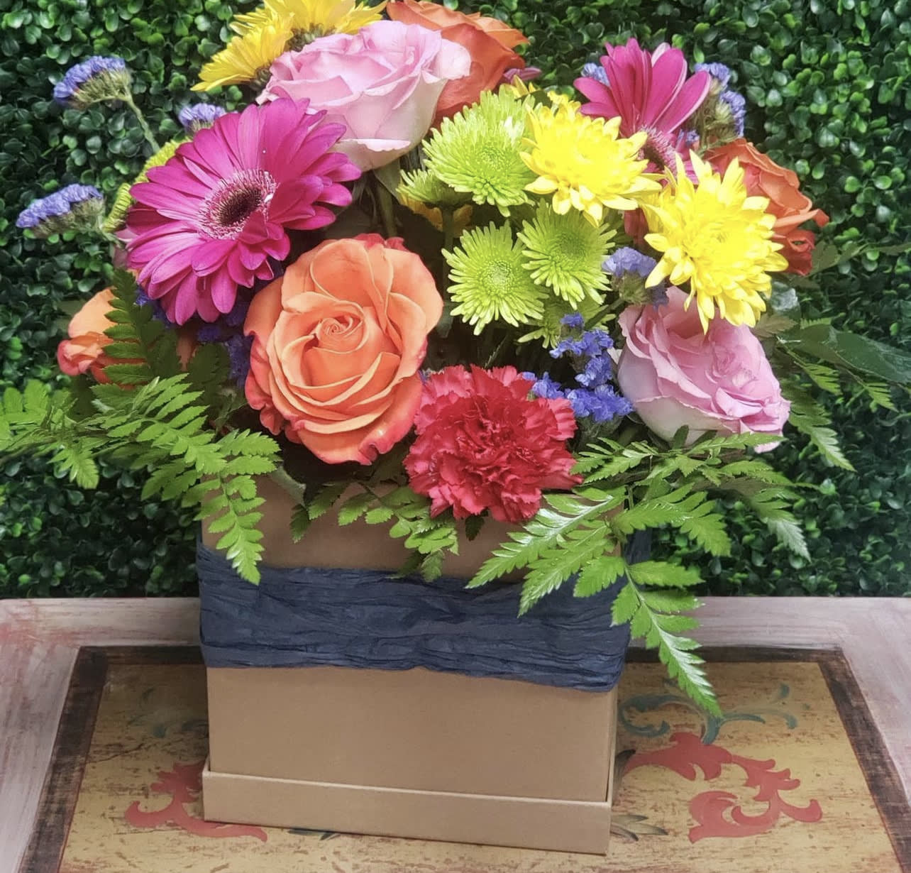 Colorful mixed bouquet in a square box with roses, gerberas, and mums
